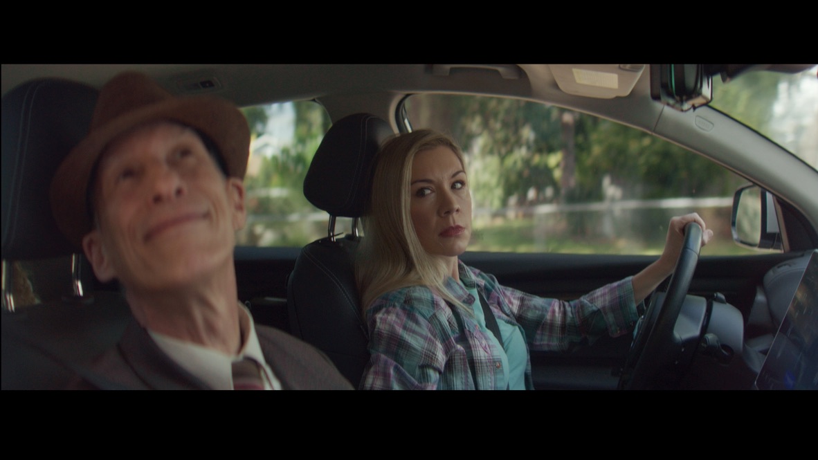 An older man and a woman seated in a car