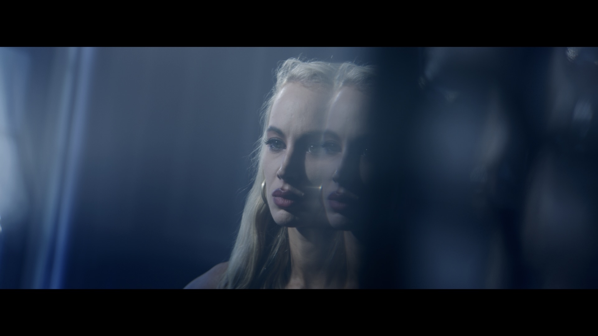 A woman’s face reflected in blue light