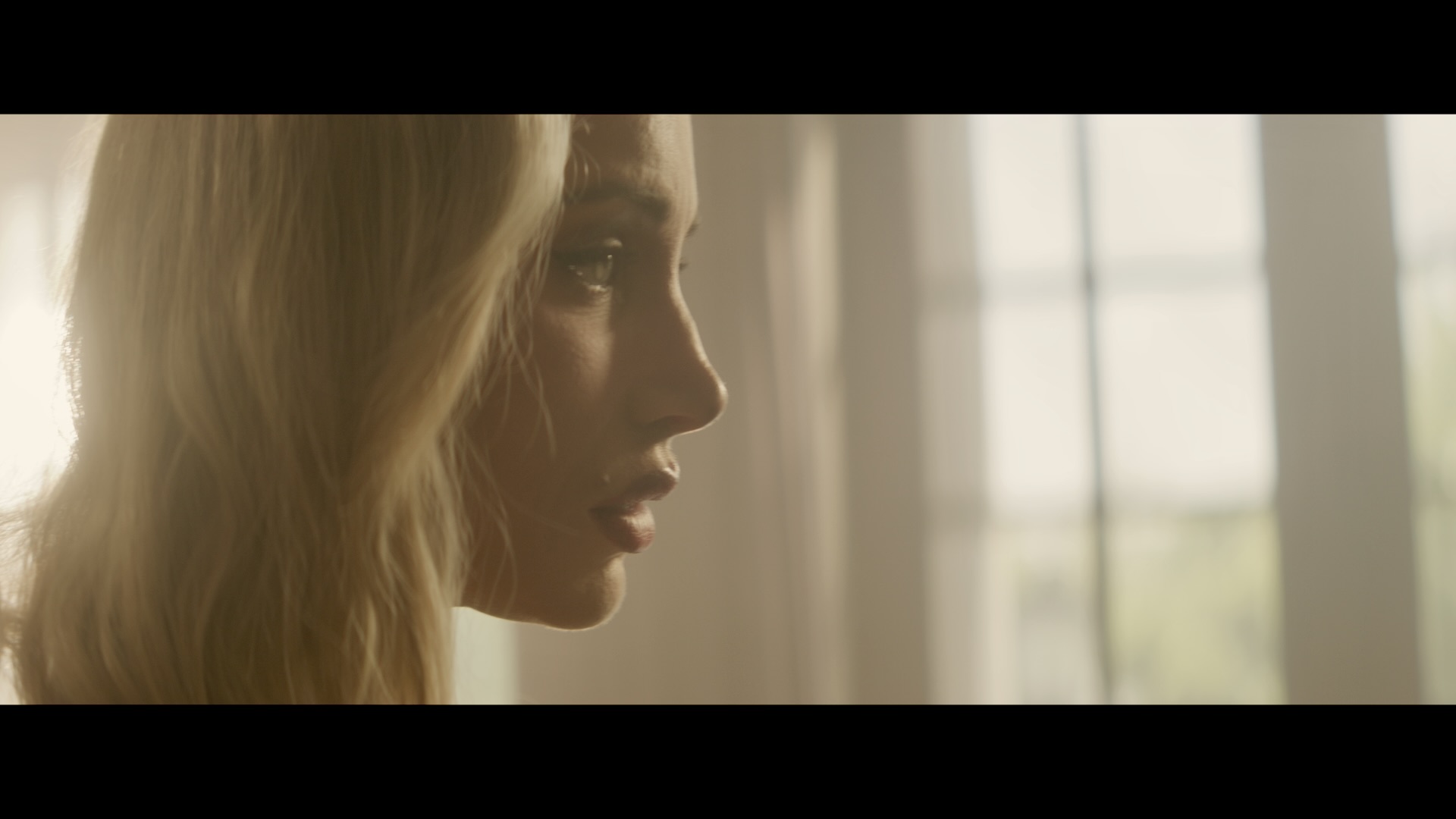 A woman in profile beside a sunlit window